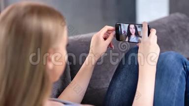 两个快乐的年轻女人一起享受视频网络摄像头，用智能手机特写聊天